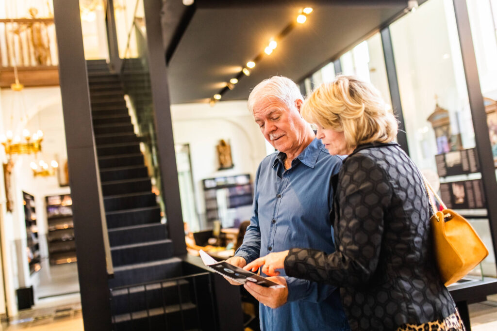 Ouder koppel bekijkt informatie in het informatiecentrum.