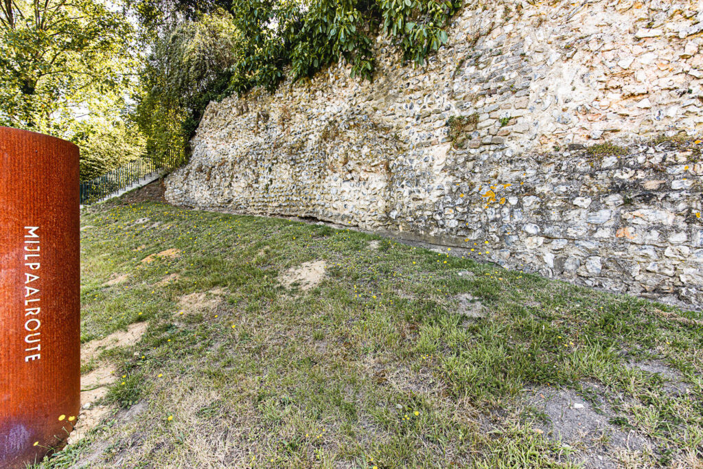 Romeinse muur met route bord.