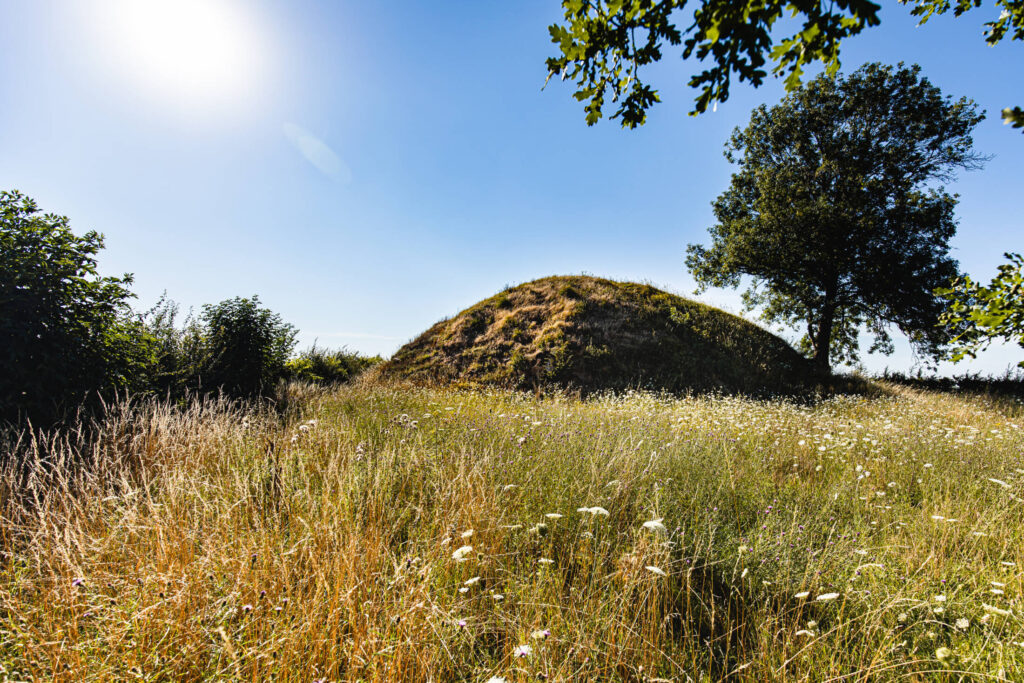 De tumulus in een open grasveld op een zonnige dag.
